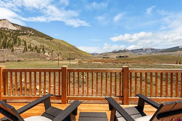 smiling realtor in front of a charming home in Crested Butte CO